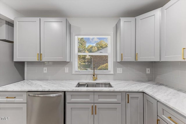 kitchen featuring decorative backsplash, stainless steel dishwasher, sink, and light stone counters