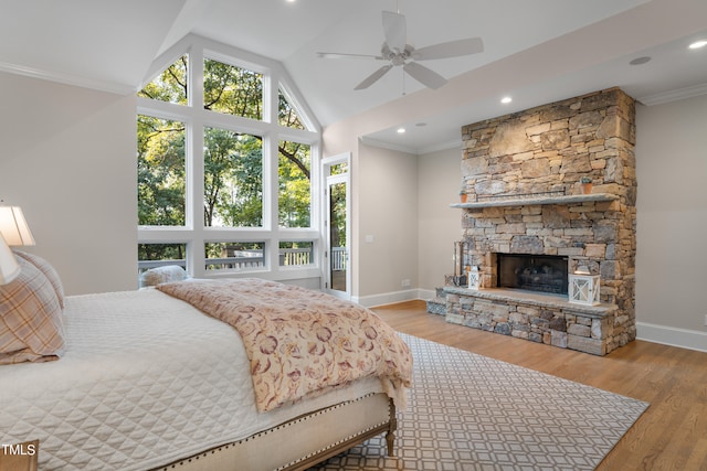 bedroom with lofted ceiling, a fireplace, crown molding, and light hardwood / wood-style floors