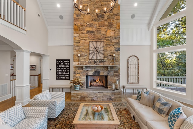 living room featuring wood-type flooring, a stone fireplace, wood ceiling, and high vaulted ceiling