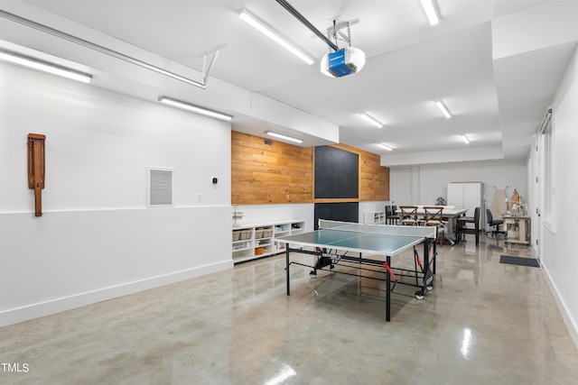 playroom with concrete floors and wooden walls