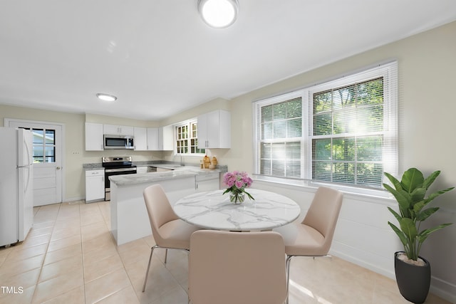 dining space with light tile patterned flooring, a healthy amount of sunlight, and sink