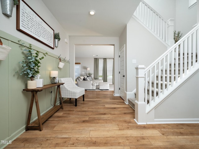 entryway featuring light wood-type flooring, baseboards, recessed lighting, and stairs