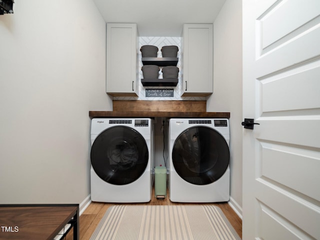 clothes washing area featuring washer and dryer, cabinet space, light wood-style flooring, and baseboards