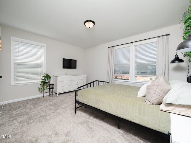 bedroom with baseboards and light colored carpet