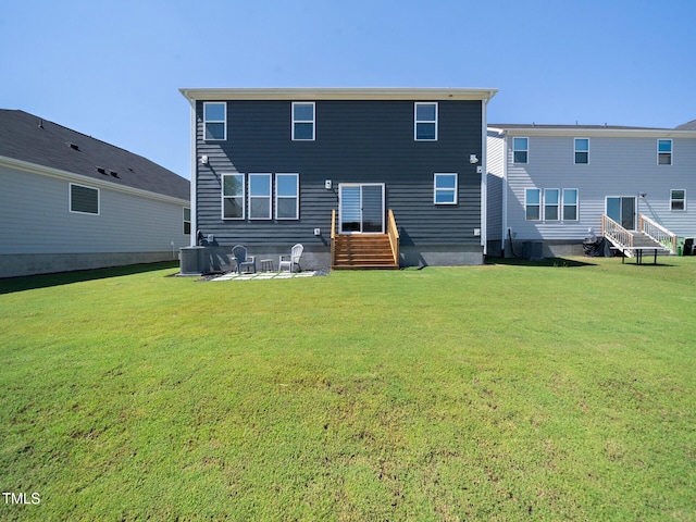 back of property featuring entry steps, a yard, and central AC