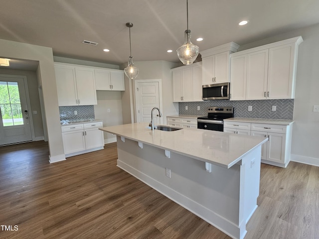 kitchen with visible vents, a sink, decorative backsplash, appliances with stainless steel finishes, and white cabinetry