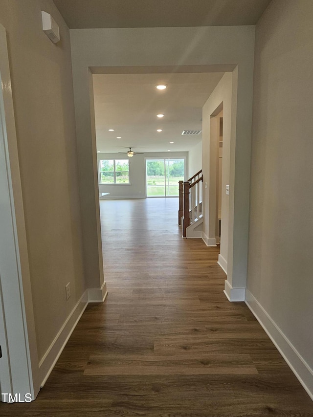 hall with baseboards, recessed lighting, stairway, and dark wood-style flooring