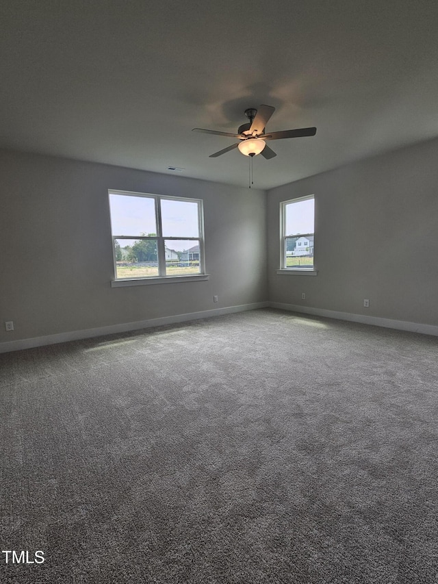 empty room with a ceiling fan, baseboards, and carpet floors