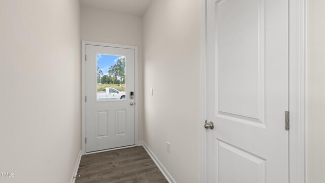 doorway to outside featuring baseboards and dark wood-style flooring