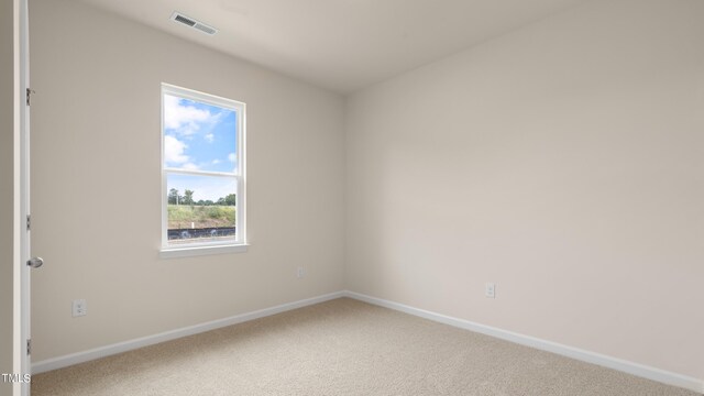 spare room with visible vents, carpet flooring, and baseboards