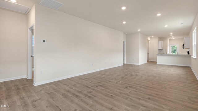 unfurnished living room with recessed lighting, light wood-type flooring, visible vents, and baseboards