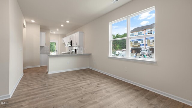 unfurnished living room with baseboards, light wood-style floors, and recessed lighting
