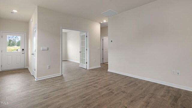interior space with baseboards, wood finished floors, visible vents, and recessed lighting