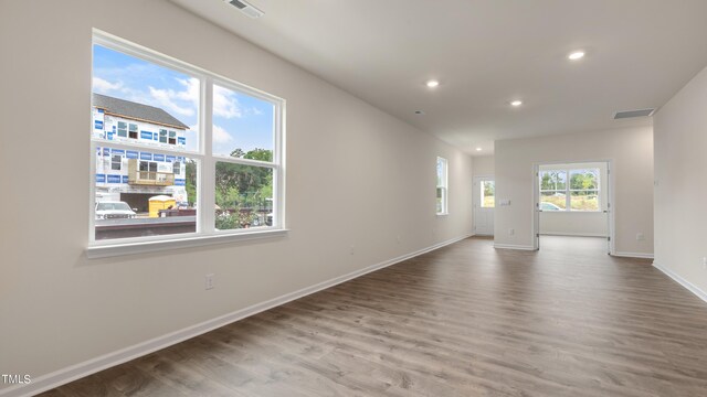 empty room featuring baseboards, wood finished floors, visible vents, and recessed lighting