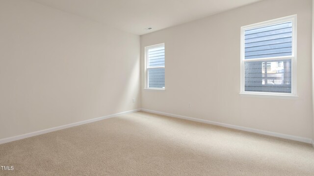 unfurnished room featuring baseboards and light colored carpet