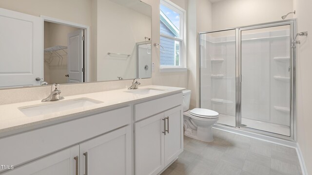 bathroom with tile patterned floors, a sink, a shower stall, and toilet