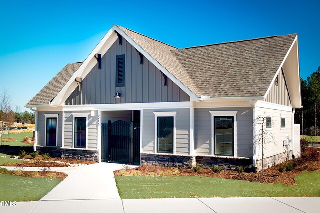 craftsman inspired home with stone siding, board and batten siding, and a shingled roof
