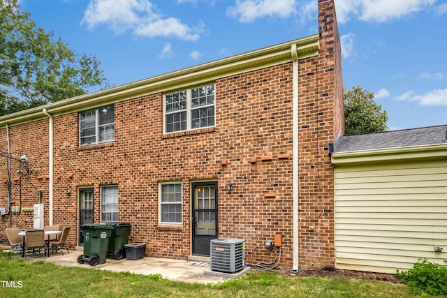 rear view of property with cooling unit and a patio area