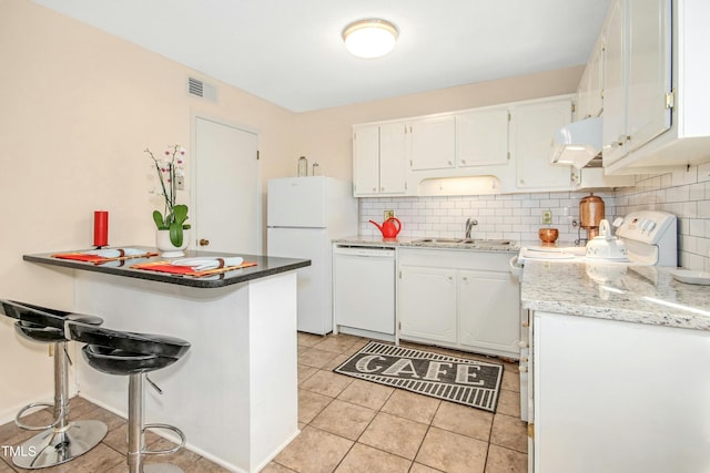 kitchen featuring white cabinets, light tile patterned floors, sink, white appliances, and decorative backsplash