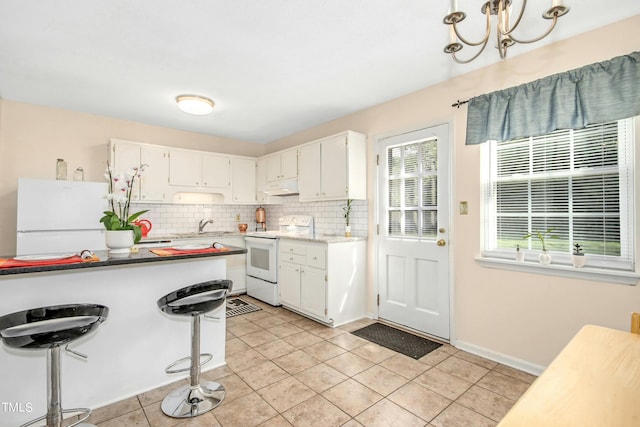 kitchen with light tile patterned floors, white appliances, tasteful backsplash, and white cabinets