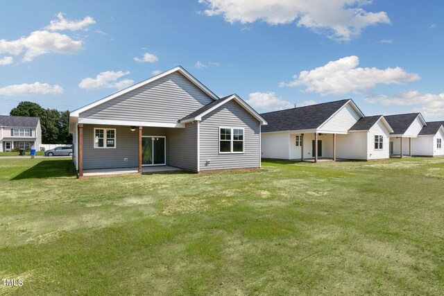 rear view of house featuring a patio and a lawn