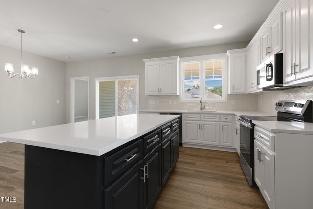 kitchen featuring tasteful backsplash, white cabinets, stainless steel appliances, a center island, and dark hardwood / wood-style floors