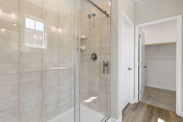 bathroom with walk in shower and hardwood / wood-style floors