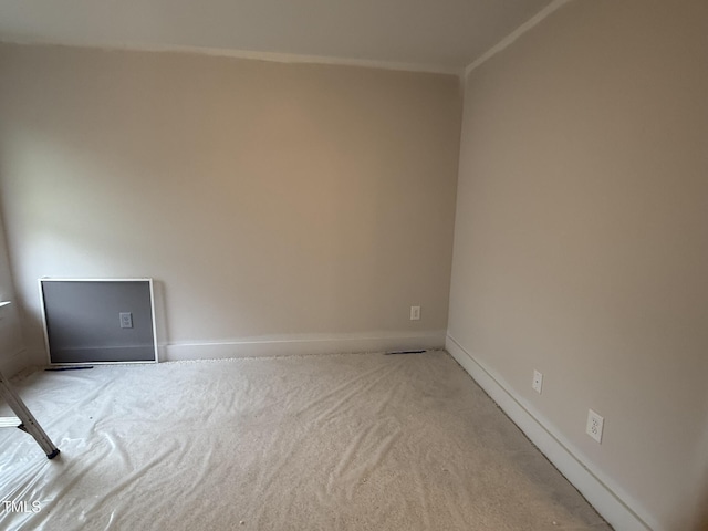 unfurnished room featuring crown molding and light carpet