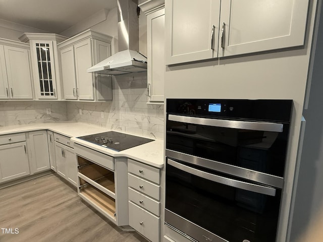 kitchen featuring extractor fan, white cabinetry, black electric cooktop, double wall oven, and backsplash