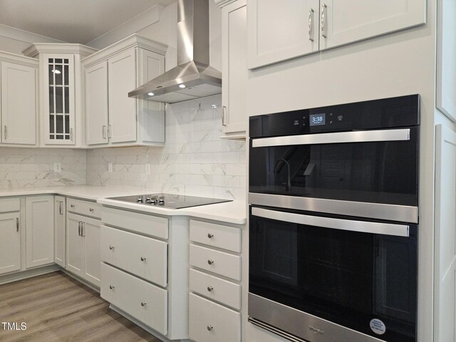 145 Green Haven Blvd Lot # 83, Youngsville, NC 27596 - kitchen with wall chimney range hood, double oven, light countertops, white cabinets, and backsplash