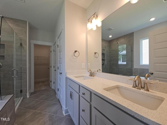 145 Green Haven Blvd Lot # 83, Youngsville, NC 27596 - bathroom with double vanity, a shower stall, tile patterned floors, and a spacious closet