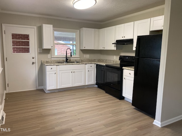 kitchen with black appliances, white cabinetry, and sink