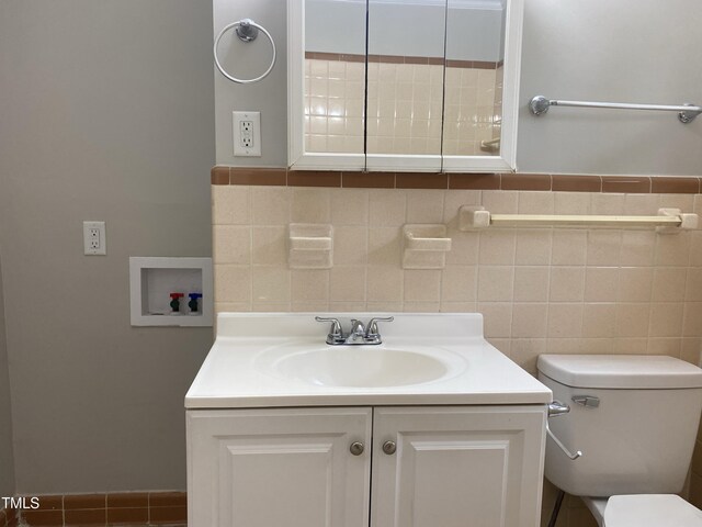 bathroom with tile walls, vanity, and toilet