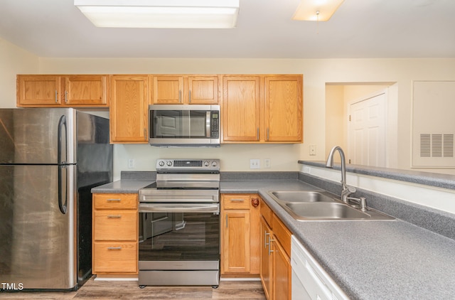 kitchen featuring appliances with stainless steel finishes, hardwood / wood-style floors, and sink