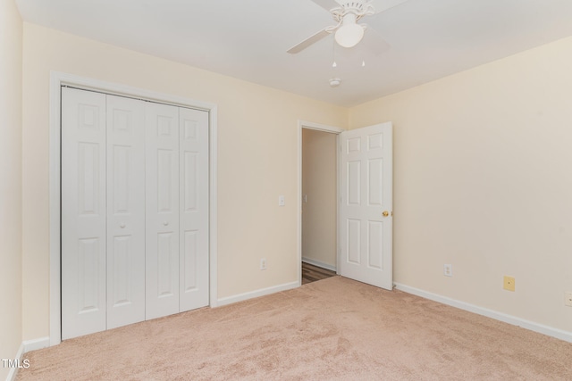 unfurnished bedroom featuring ceiling fan, a closet, and carpet flooring