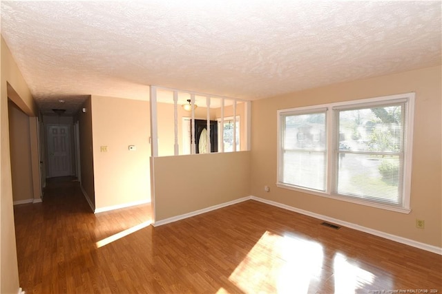 empty room featuring a textured ceiling and hardwood / wood-style flooring