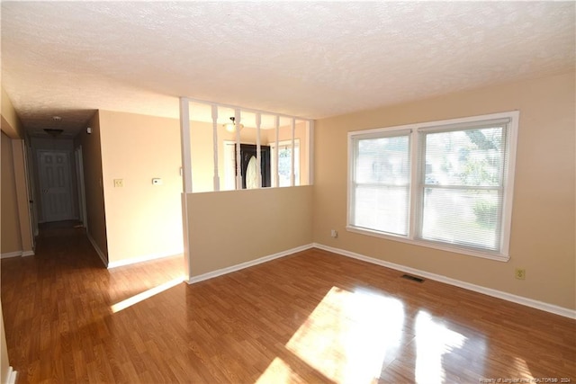 spare room featuring a textured ceiling and wood-type flooring