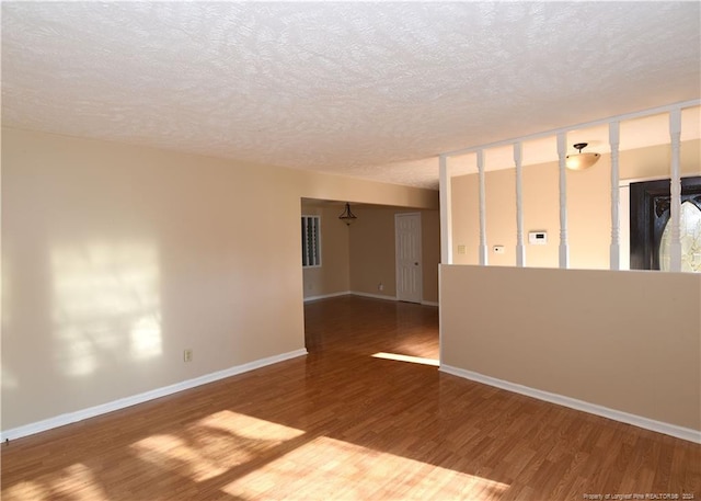 unfurnished room featuring a textured ceiling and hardwood / wood-style floors