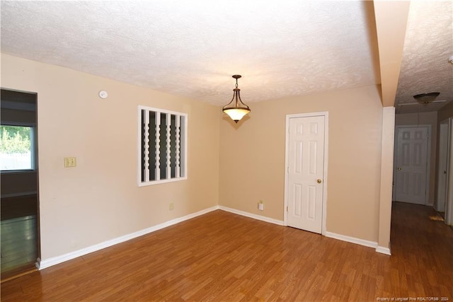 unfurnished room featuring a textured ceiling and hardwood / wood-style floors