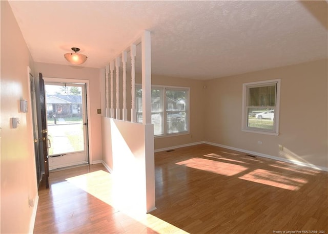 entrance foyer with a textured ceiling and hardwood / wood-style flooring