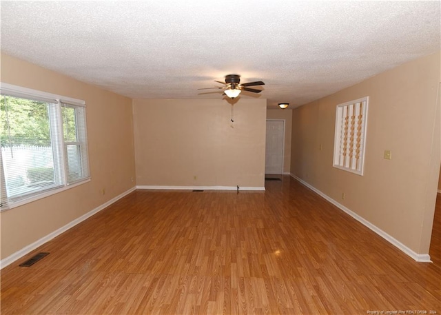 spare room featuring light hardwood / wood-style flooring, ceiling fan, and a textured ceiling