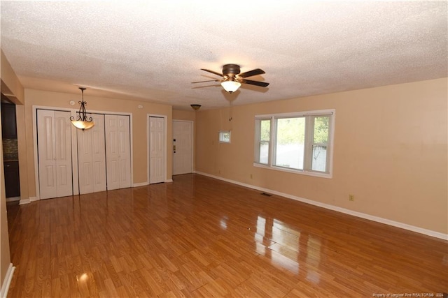 unfurnished living room featuring a textured ceiling, ceiling fan, and hardwood / wood-style flooring