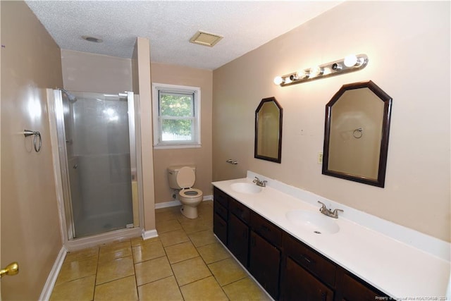 bathroom with tile patterned flooring, a textured ceiling, a shower with shower door, vanity, and toilet