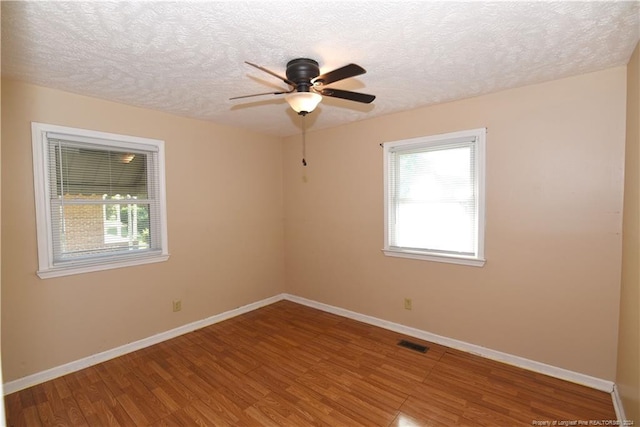 spare room featuring ceiling fan, hardwood / wood-style floors, and a textured ceiling