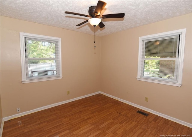 unfurnished room with ceiling fan, a textured ceiling, and hardwood / wood-style floors