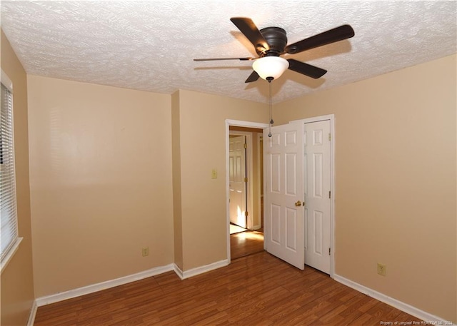 unfurnished bedroom featuring ceiling fan, hardwood / wood-style flooring, and a textured ceiling