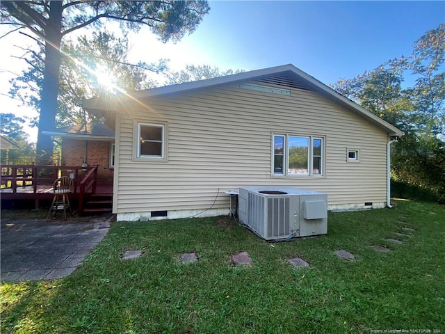 back of property featuring a wooden deck, central AC unit, and a yard