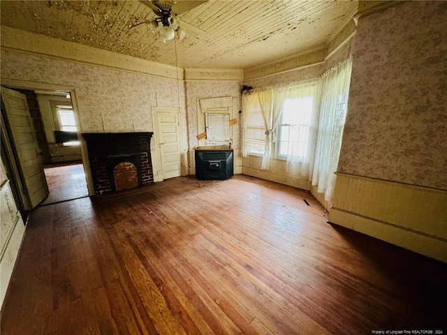 unfurnished living room featuring ceiling fan and hardwood / wood-style flooring