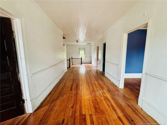 corridor with crown molding and hardwood / wood-style floors