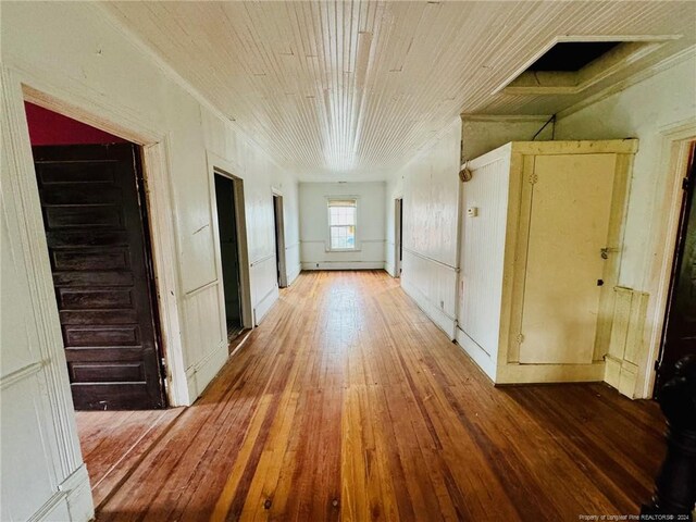 hallway featuring wood-type flooring and ornamental molding